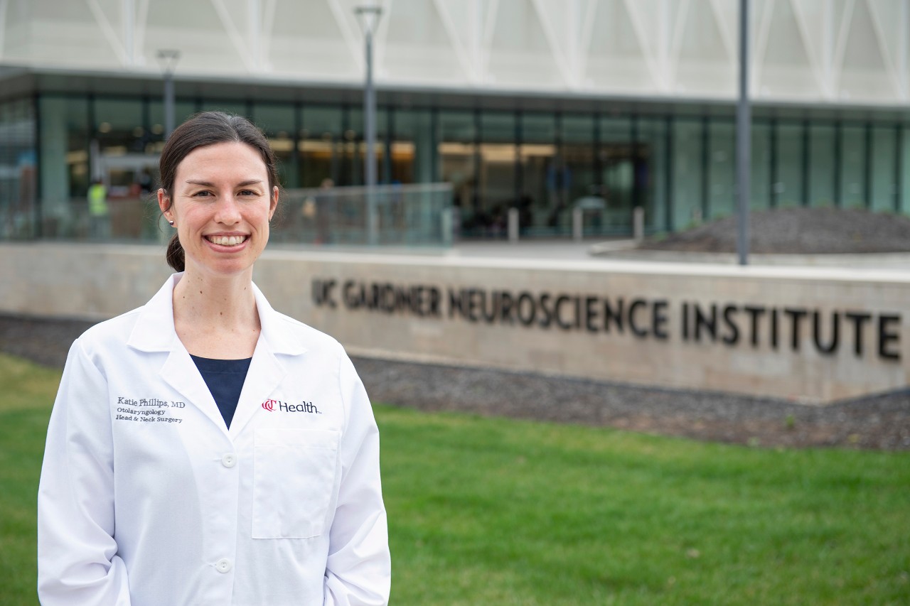 a woman in a lab coat standing outside a building