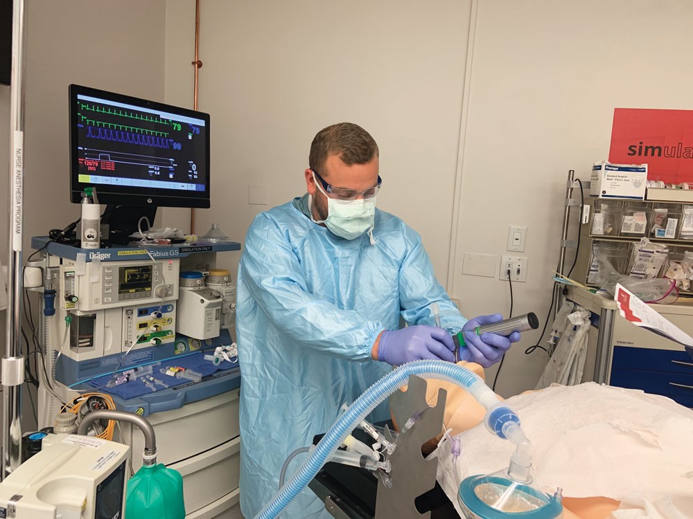 Adam Mollinger practices intubation in UC College of Nursing's simulation lab