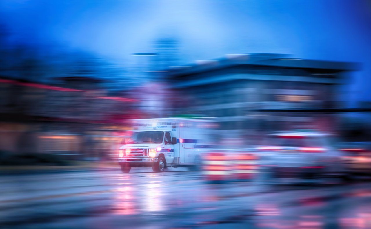 Ambulance moving through a city in the evening