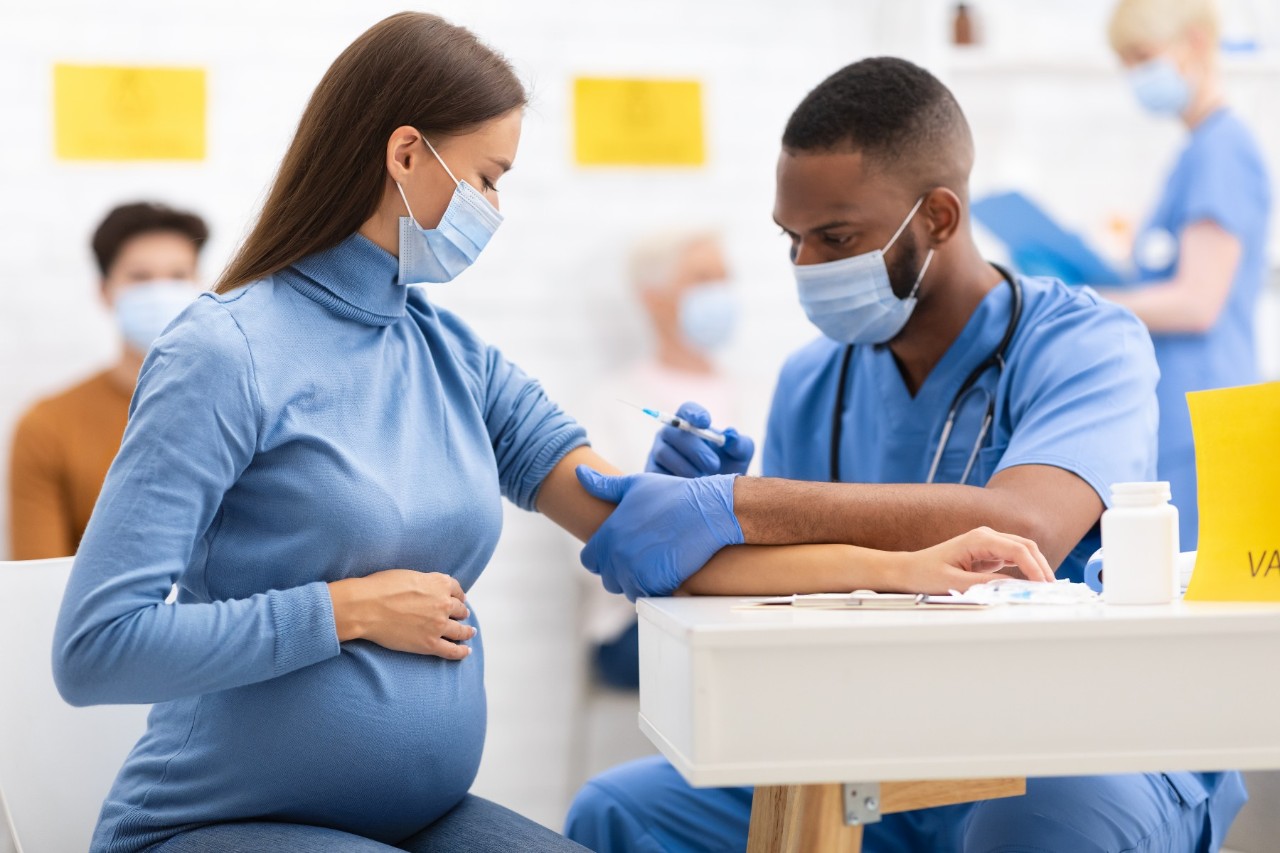 a pregnant woman receiving a vaccine shot