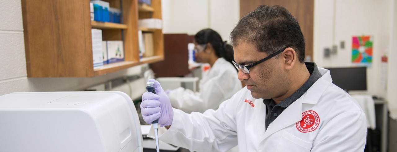 Dr. Kotagiri injects a sample into a test tube in his laboratory