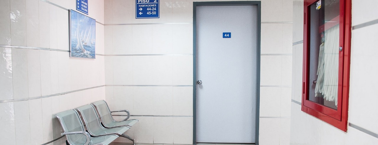 generic waiting room at a clinic with chairs and a door