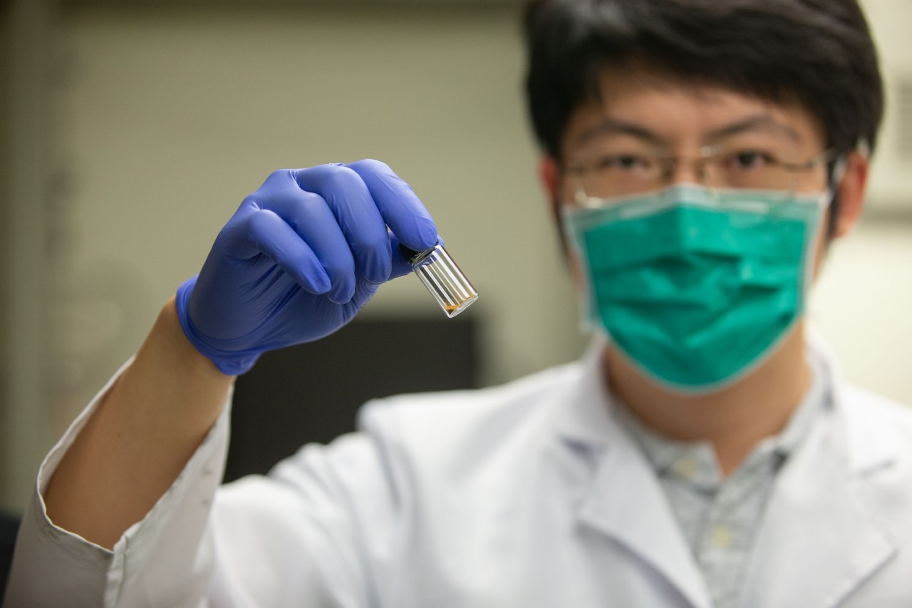UC student Tianyu Zhang holds up a vial of graphene.