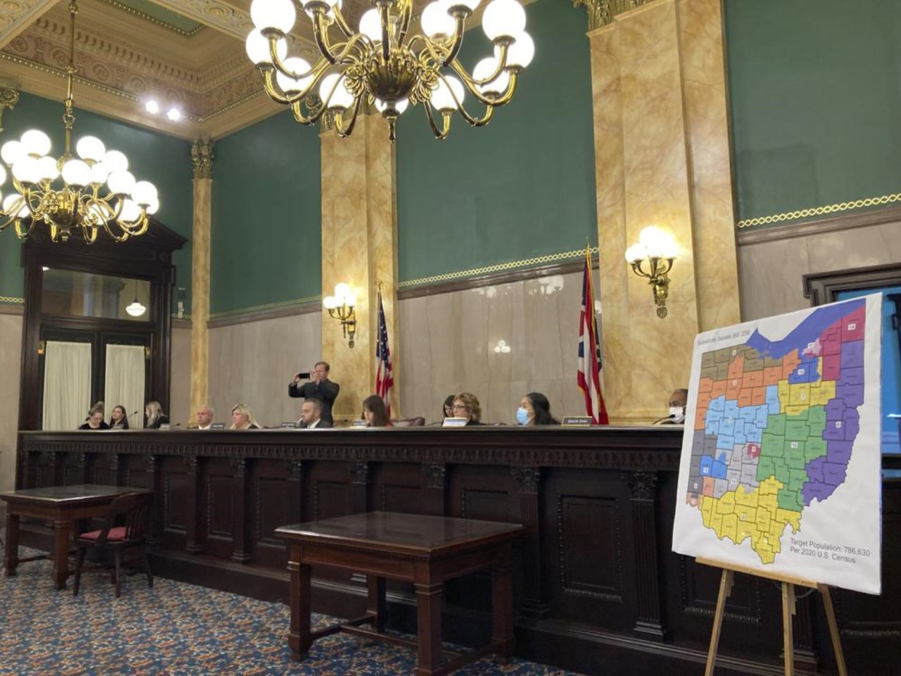Ohio legislators in session with congressional map