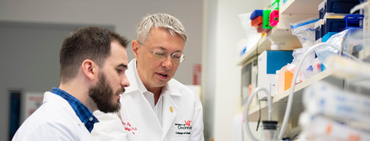 A male lab researcher and Dr. Bogdanov discuss data in the lab