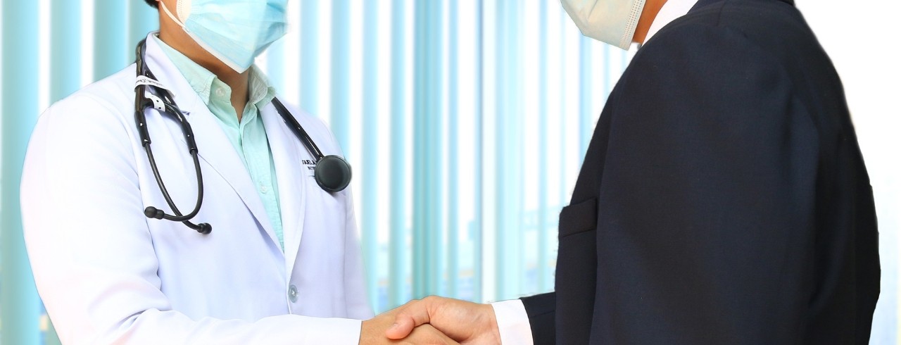 A doctor and a patient shake hands