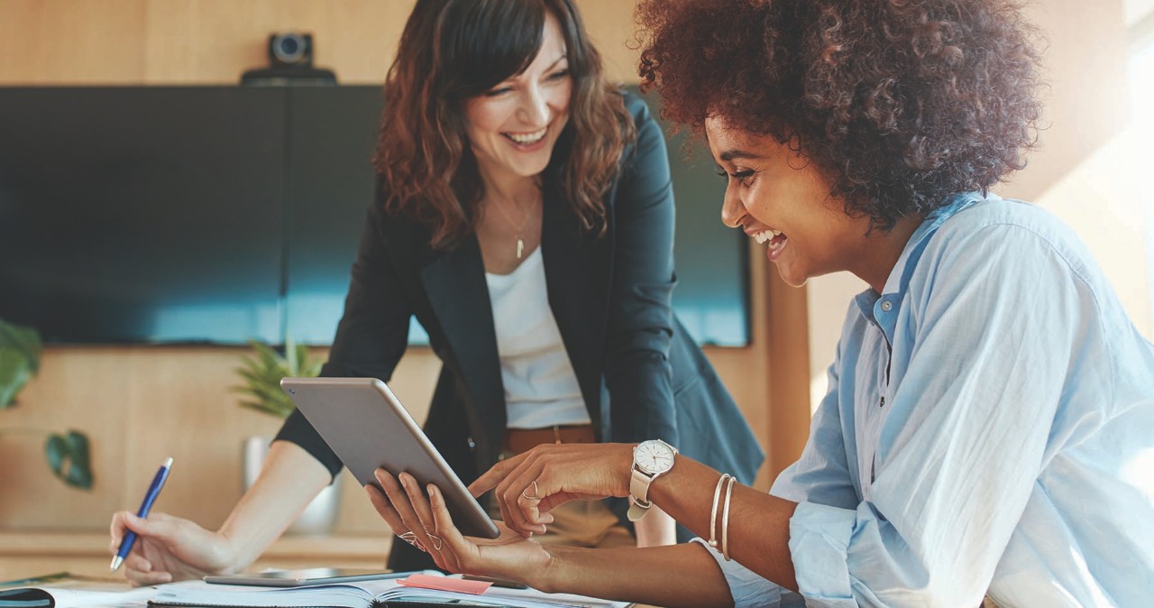 two women, one white, and one Black, working in an office setting