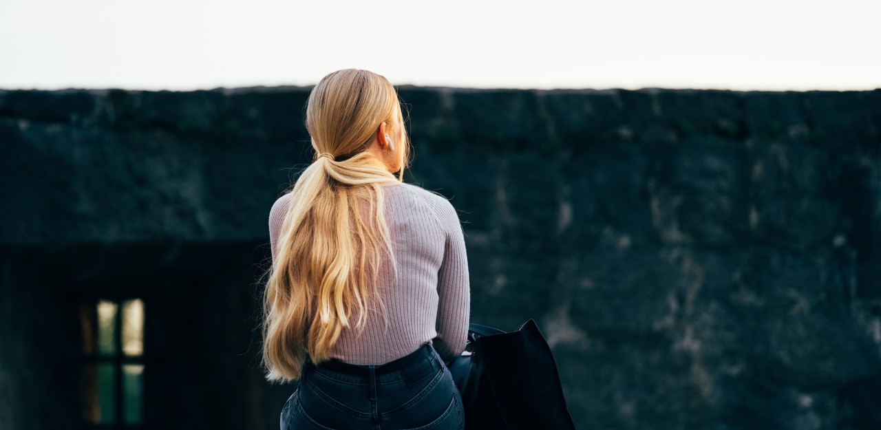 young woman with her back to the camera looking into the distance