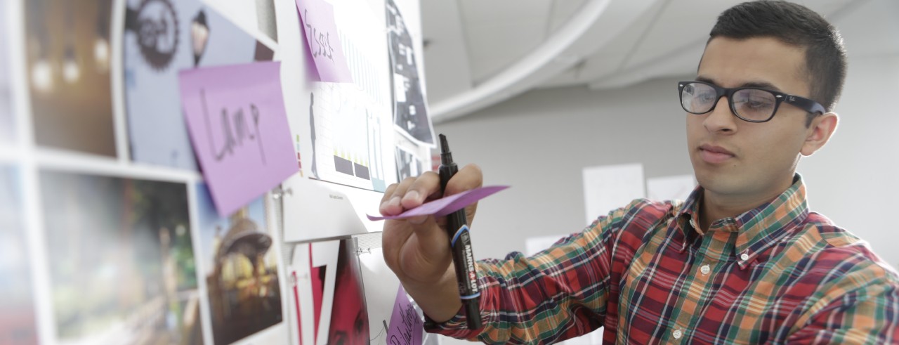 Man places Post-It on bulletin board