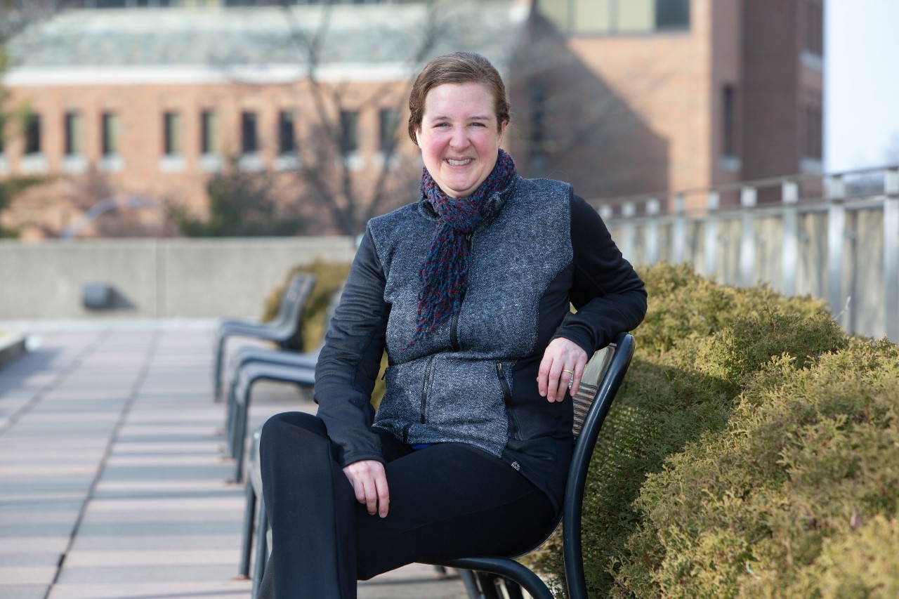 Elizabeth Hobson sits on a park bench on UC's uptown campus.
