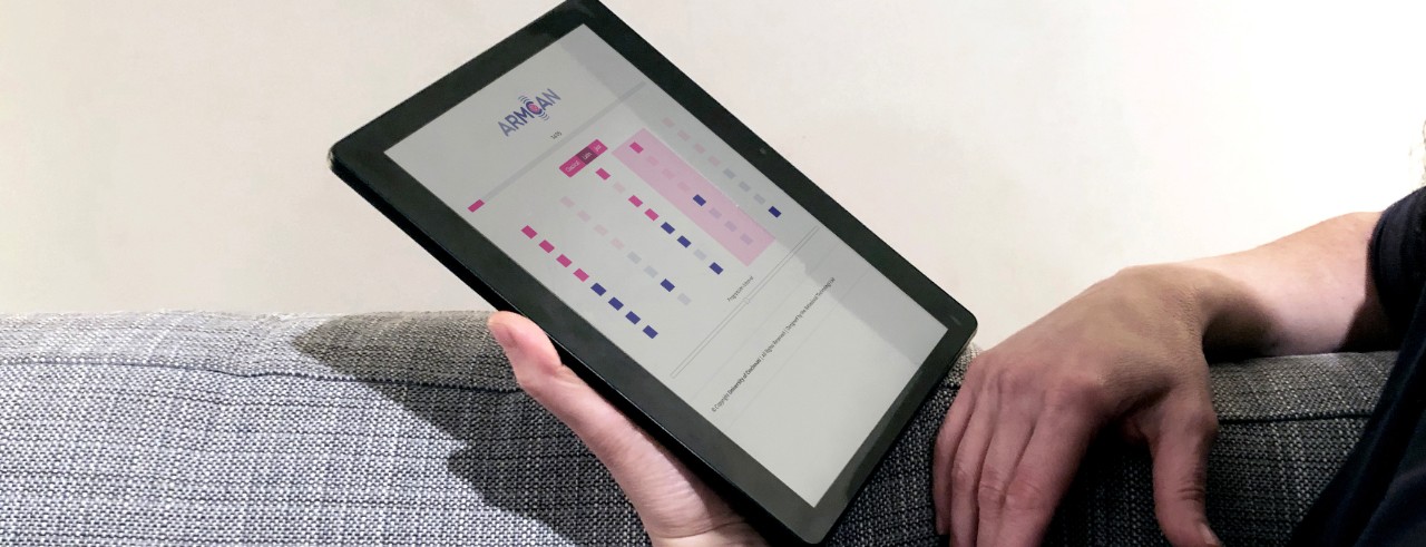 A person holds a tablet loaded with the ARMCAN therapy app