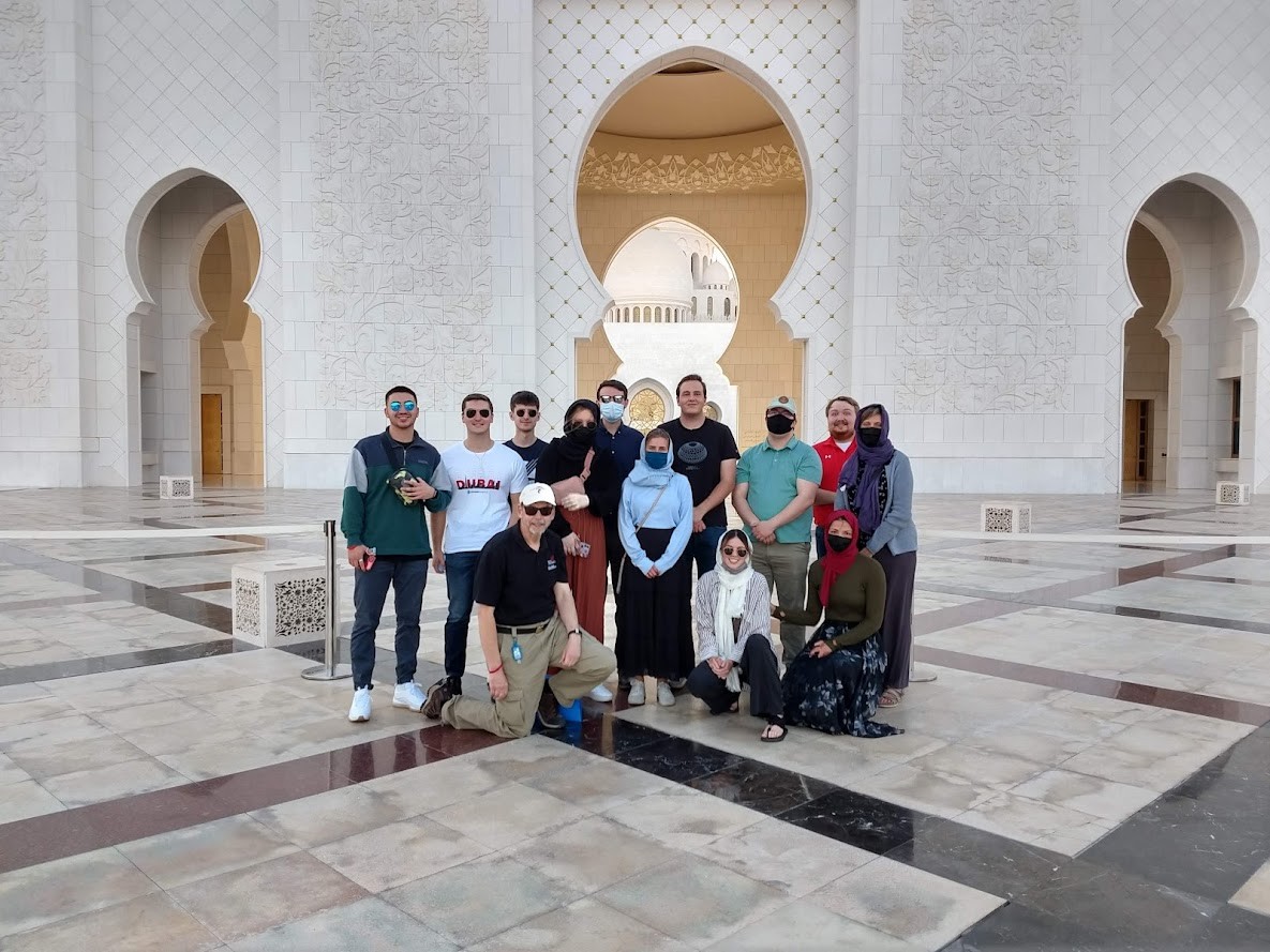 A group poses for a photo at a grand mosque.