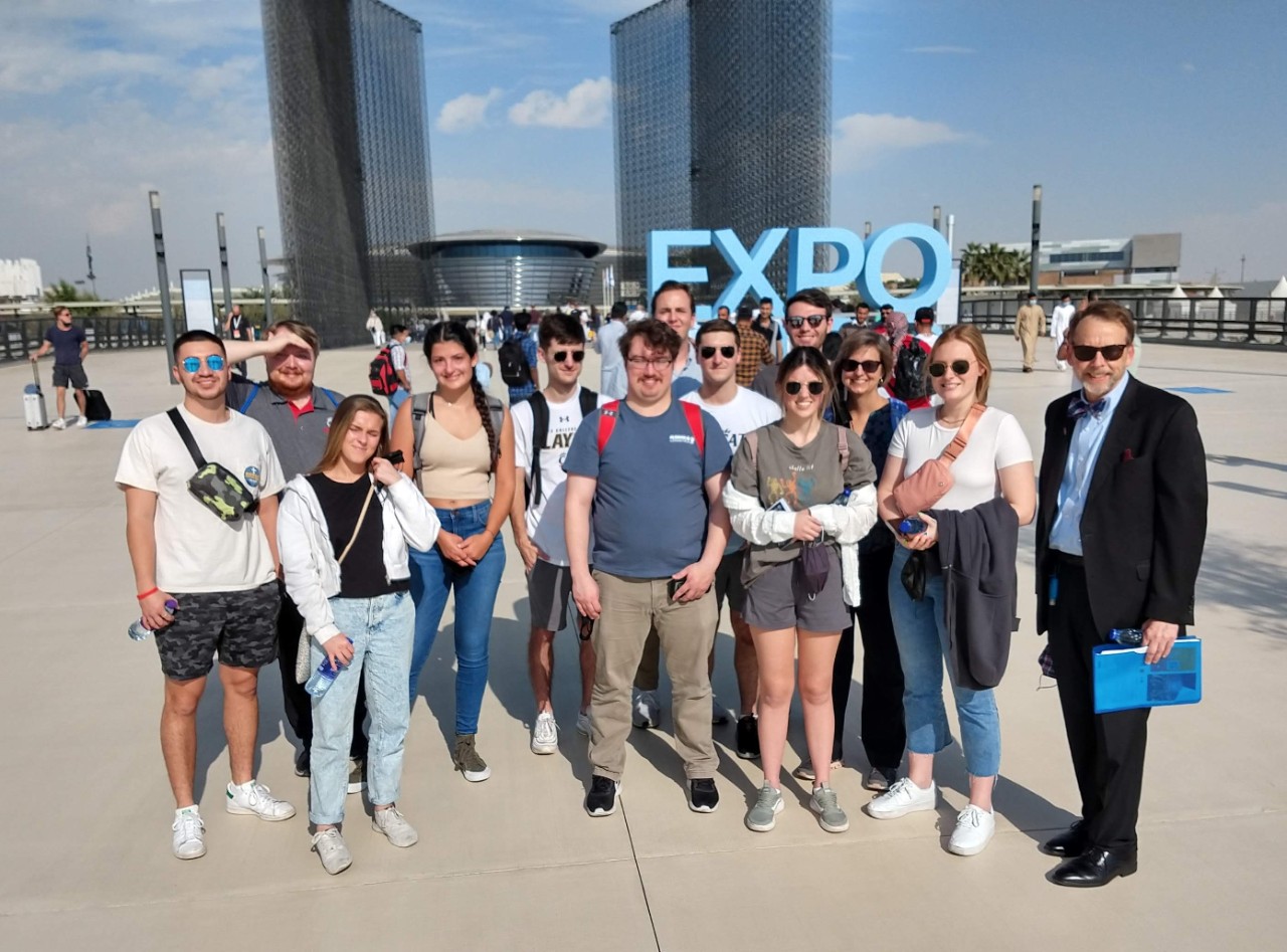 A group of people stands outside of an expo.