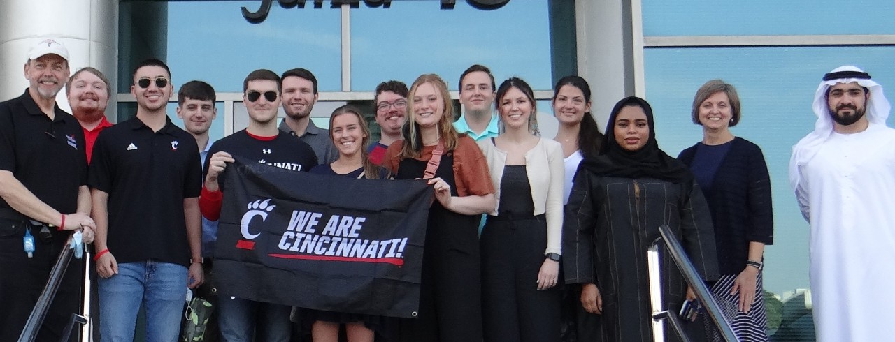 A group of people pose for a photo outside of a company in Dubai.