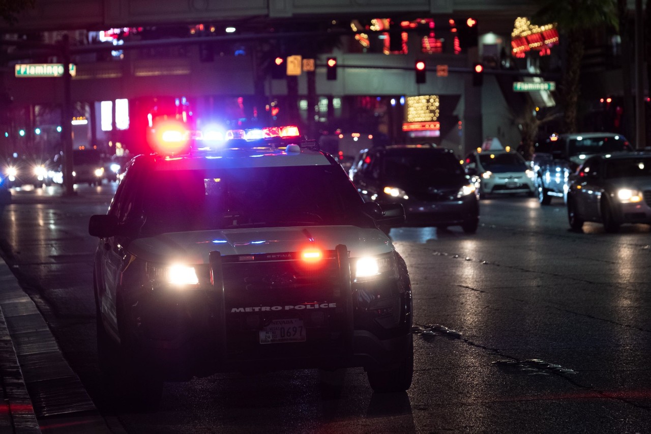 police car with lights on and metro sign on bumper at night