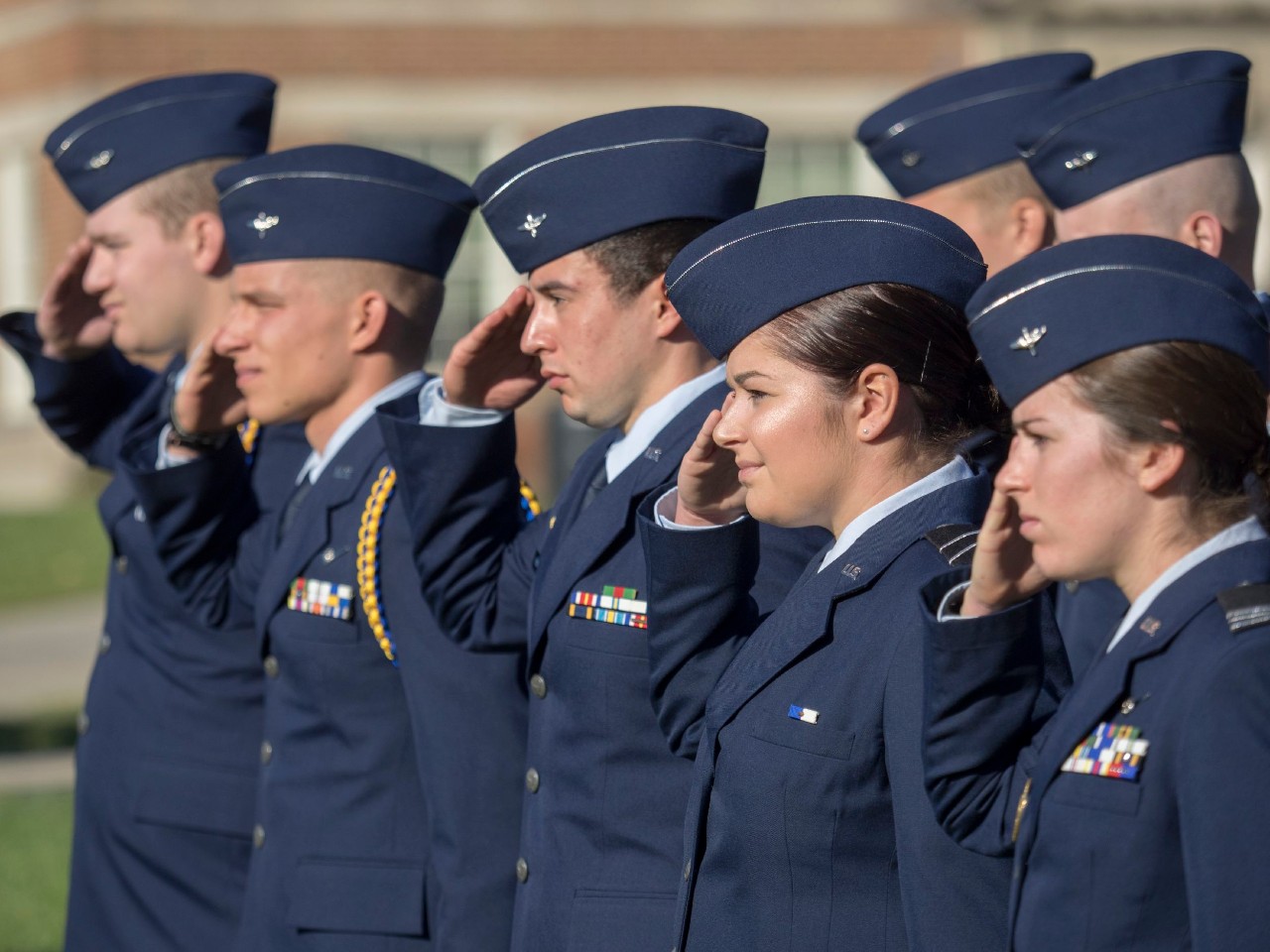 U.S. Navy ROTC students salute during a Veterans Day ceremony on UC's campus.