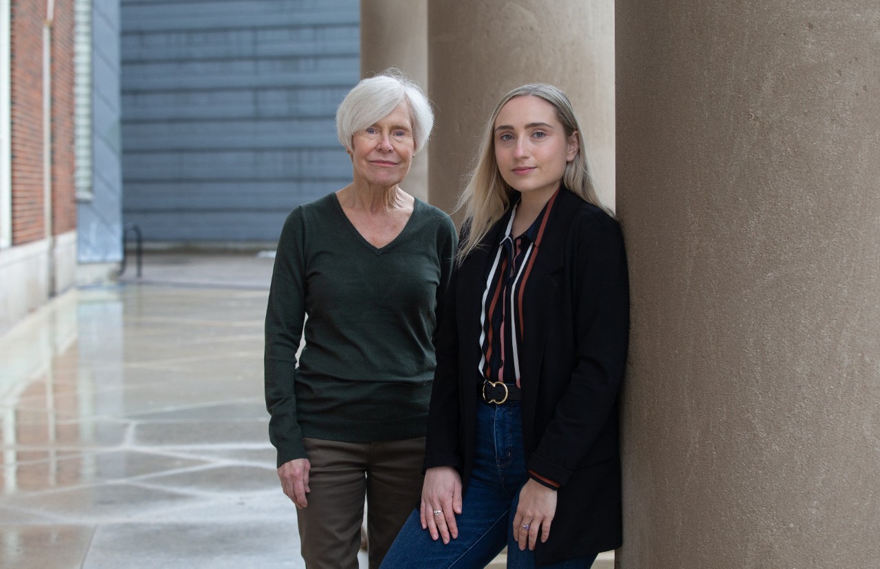 UC Clermont paralegal alumni Barbara Rugen and Elizabeth Schmitt stand together against a column.