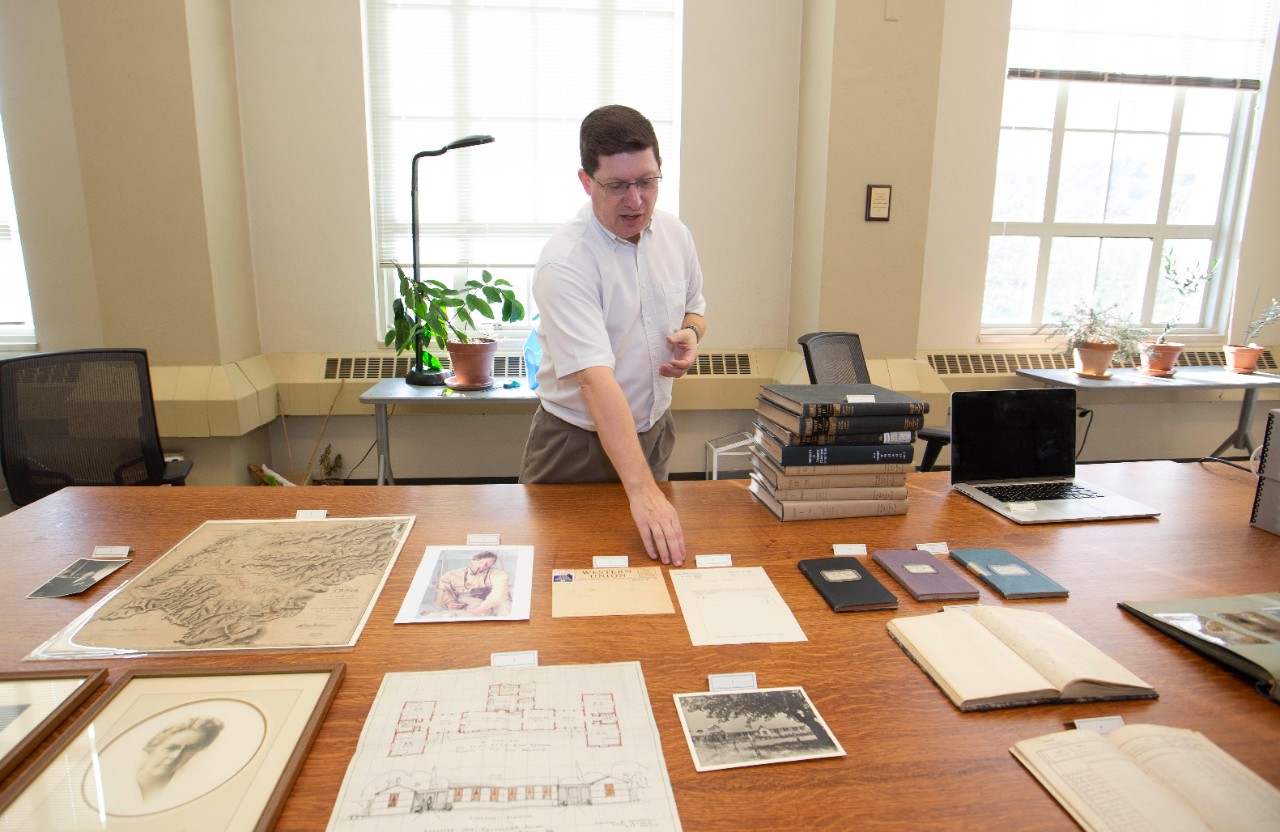 Jeff Kramer shows off documents and photos from UC's Troy archive.