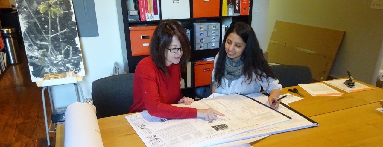 Co-op student with mentor in the office looking at drawings for a building