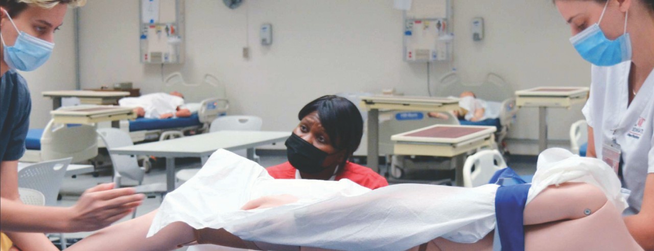 Students Ellie Cassedy, Precious Sims and Megan Cabell test a prototype in UC College of Nursing's sim lab.