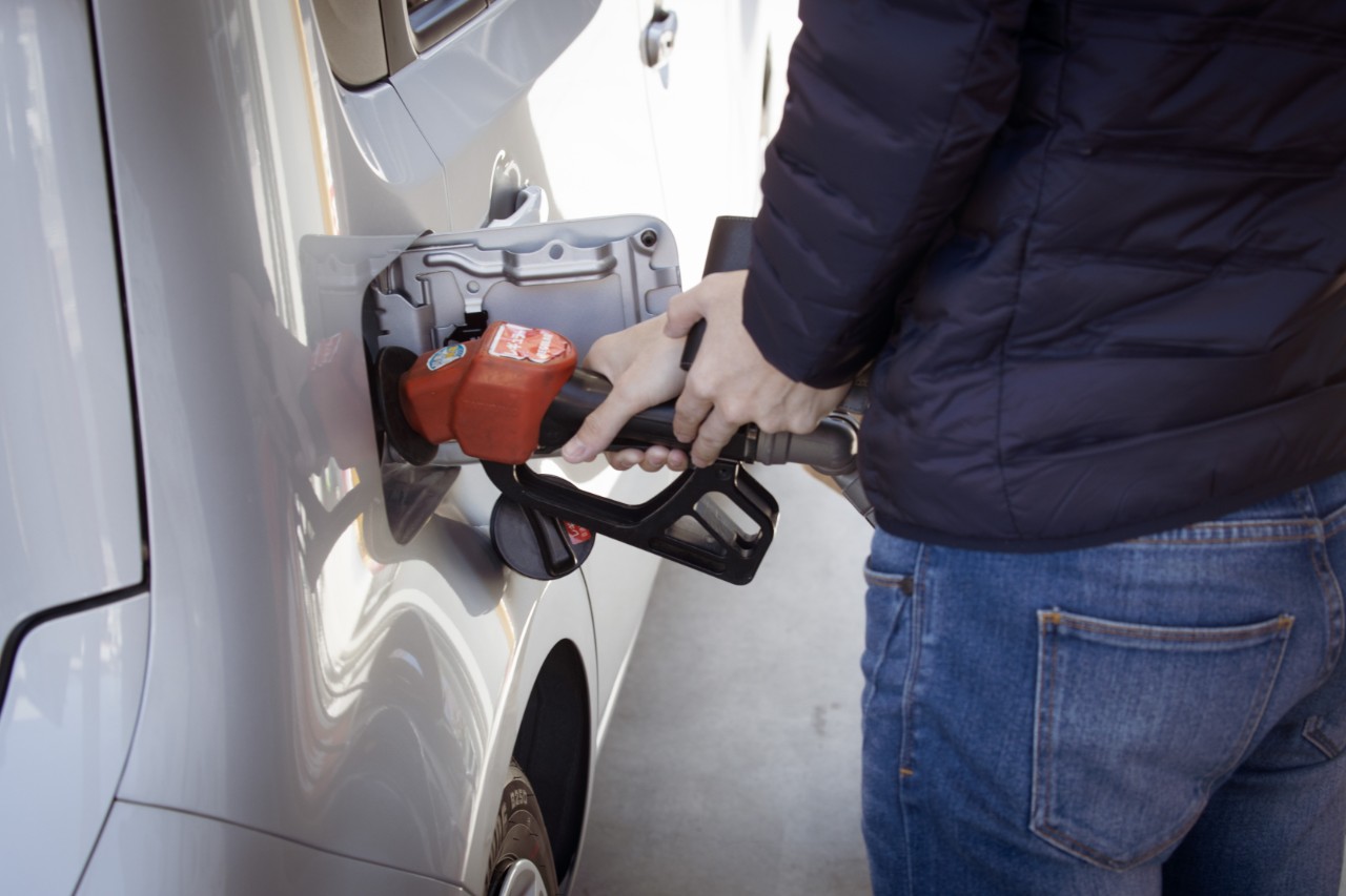 A person fills a car's gas tank.