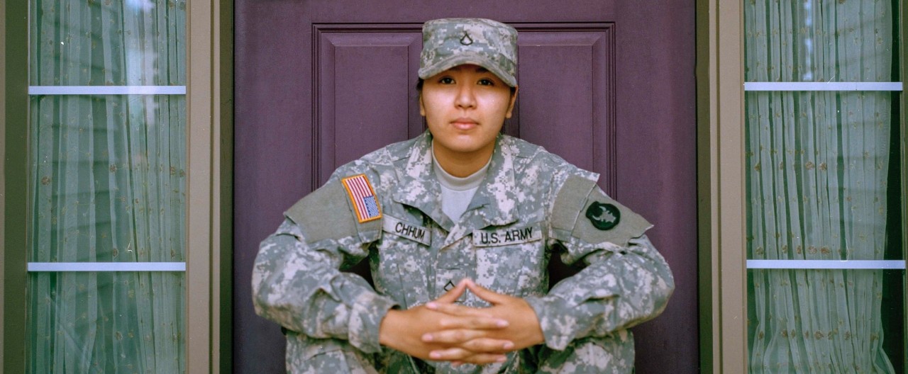 female soldier sitting on a stoop in uniform 