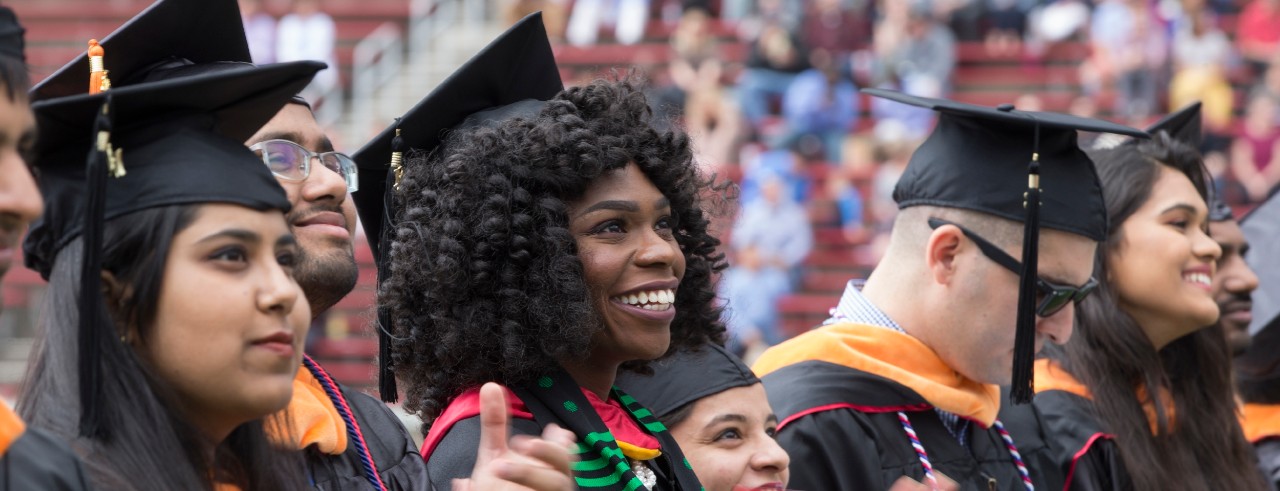 Master and doctoral graduates pose in caps and gowns