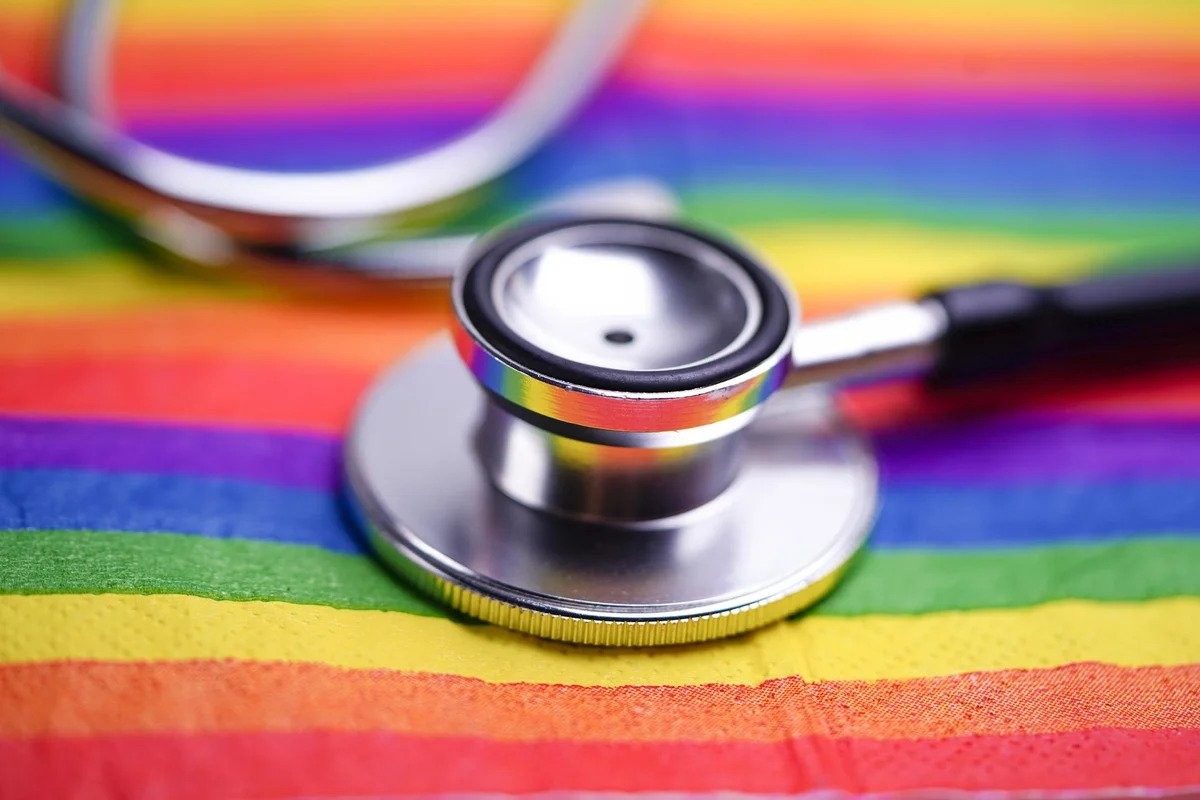 a stethoscope positioned on a gay pride flag