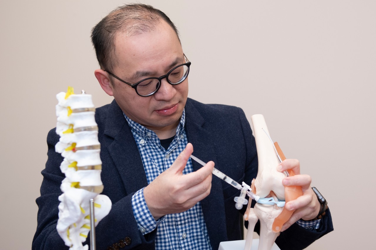 Chia-Ying James Lin injects a needle into a model of a spine.