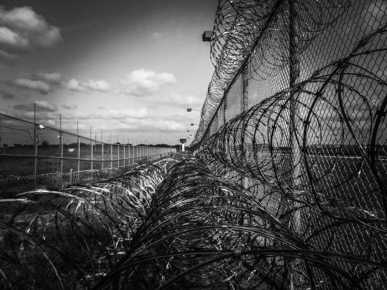 a photo of a prison fence with a roll of razor wire