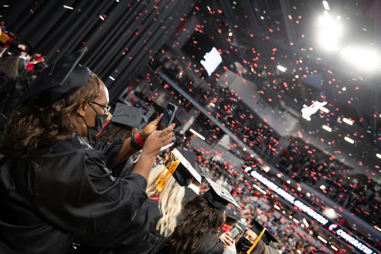 Confetti falls on graduates in caps and gowns.
