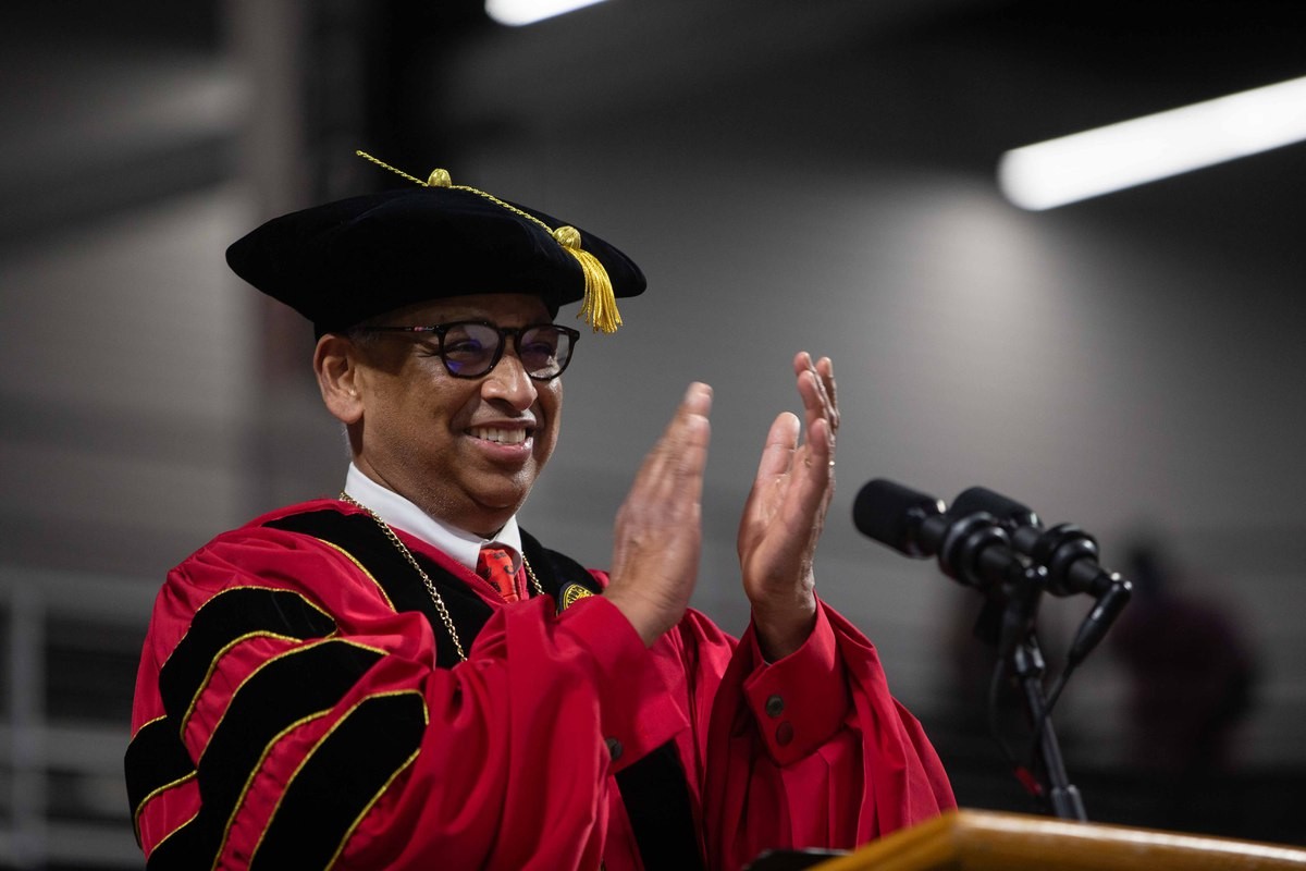 UC President Neville Pinto applauds graduates at commencement.