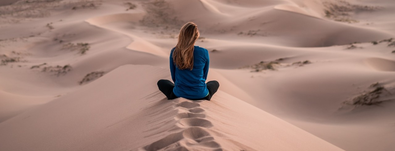 woman sitting alone in desert 