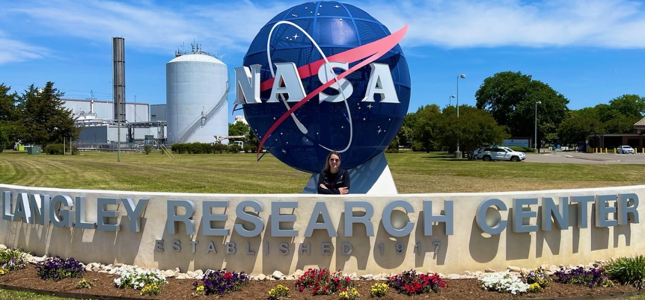 Anna Lanzillotta stands by the NASA Langley Research Center sign outside on a sunny day