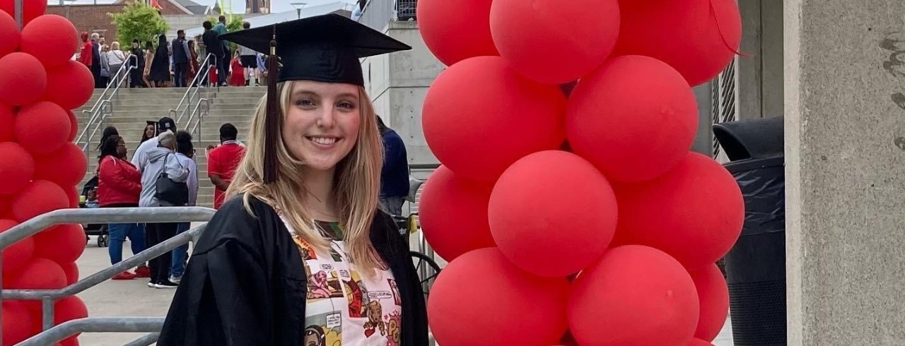 Lee Wilger in cap and gown with red ballons
