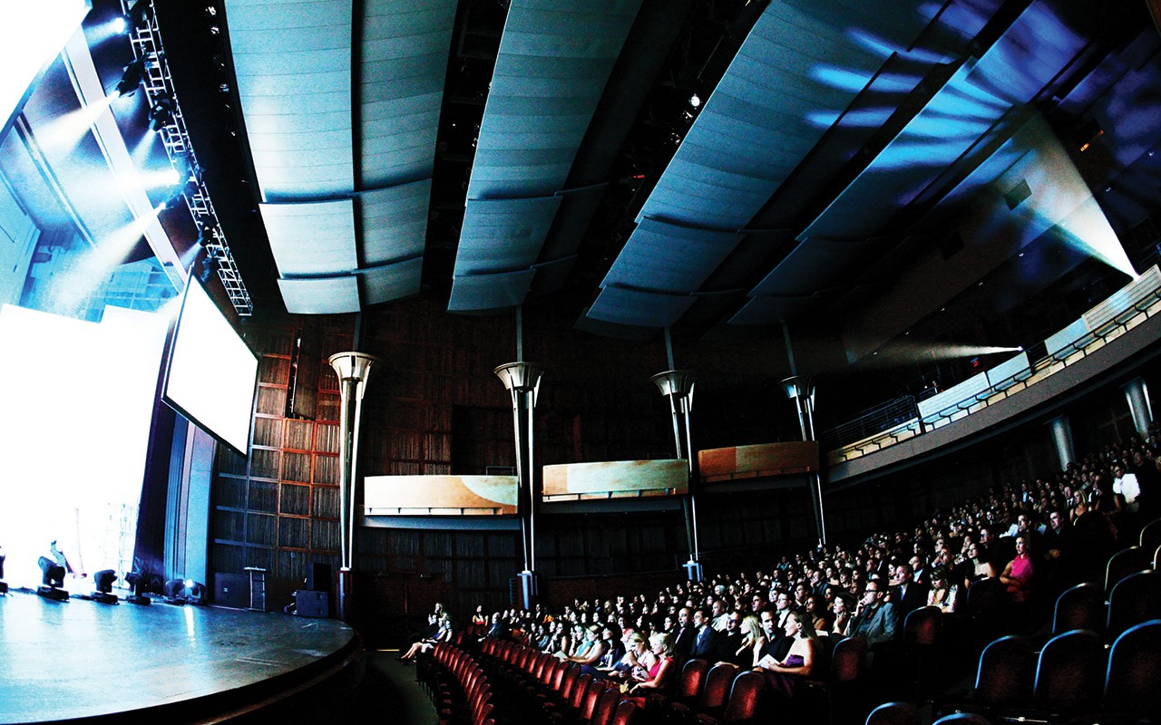 Stage lighting reveals a side view of audience sitting in Corbett Auditorium. Photo/TM Photography