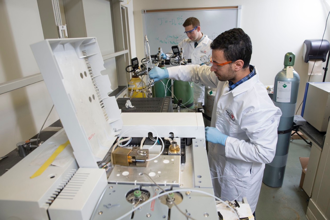 UC students in labcoats work in Jou-Youp Lee's lab. 