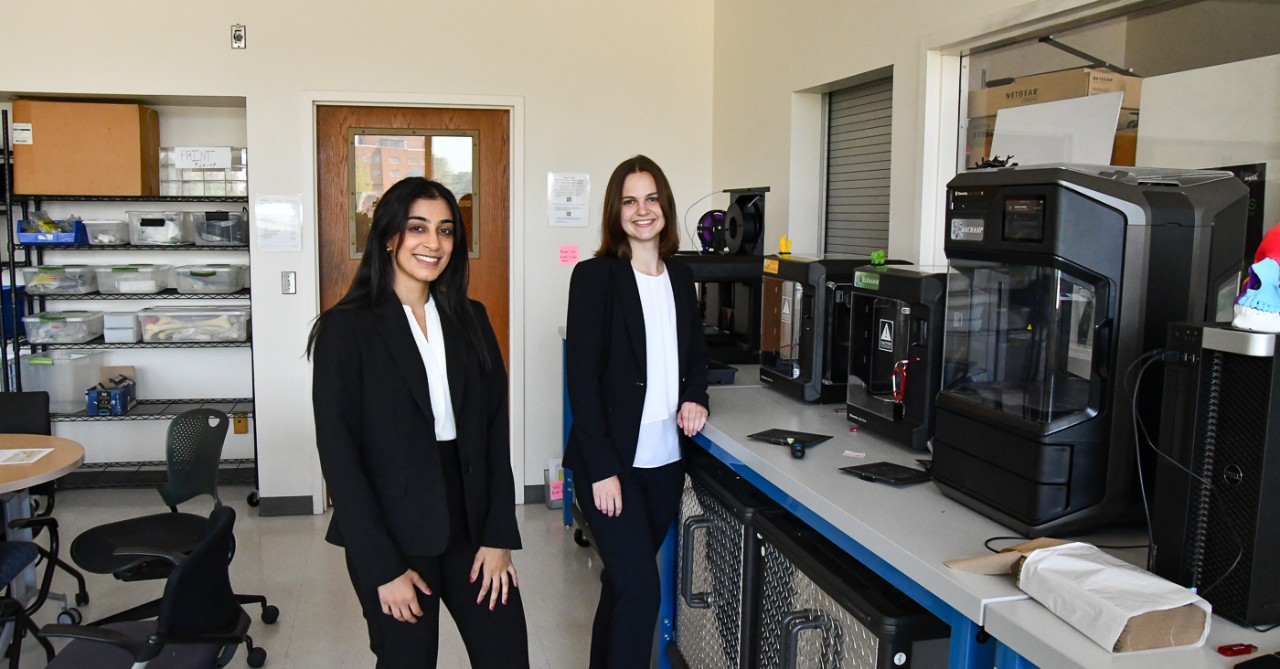 UC students stand at a bank of 3D printers in a biomedical engineering classroom.