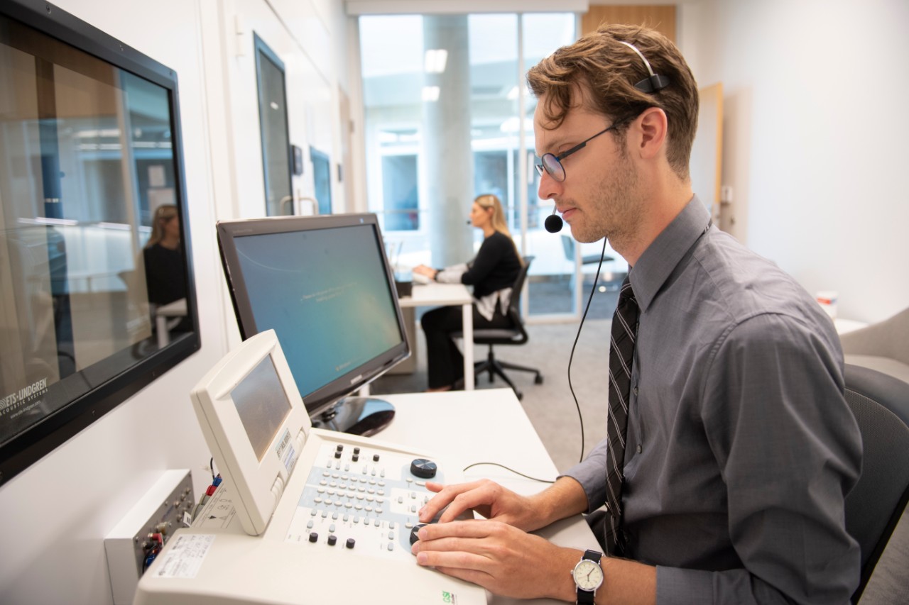 Student in the Audiology lab giving a hearing test