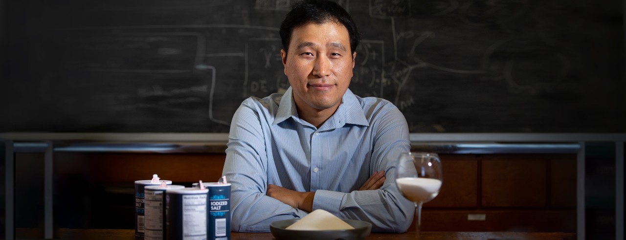 Yu Shi toasts with a wine glass of salt in front of a bowl of salt.