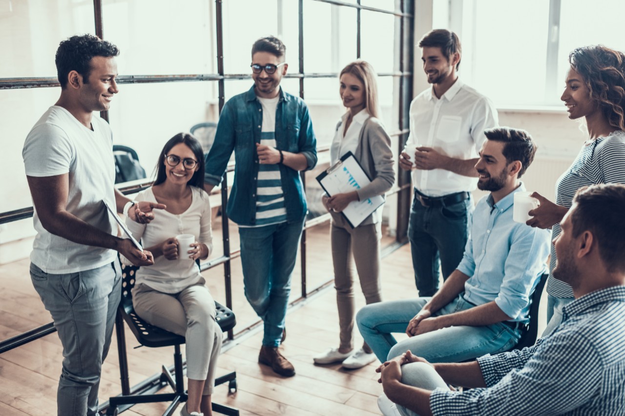 Group of Young Business People on Break in Office. Successful Business Team Talking on Coffee Break. Young Smiling Colleagues on Break Drinking Coffee Chatting in Modern Office. Corporate Lifestyle