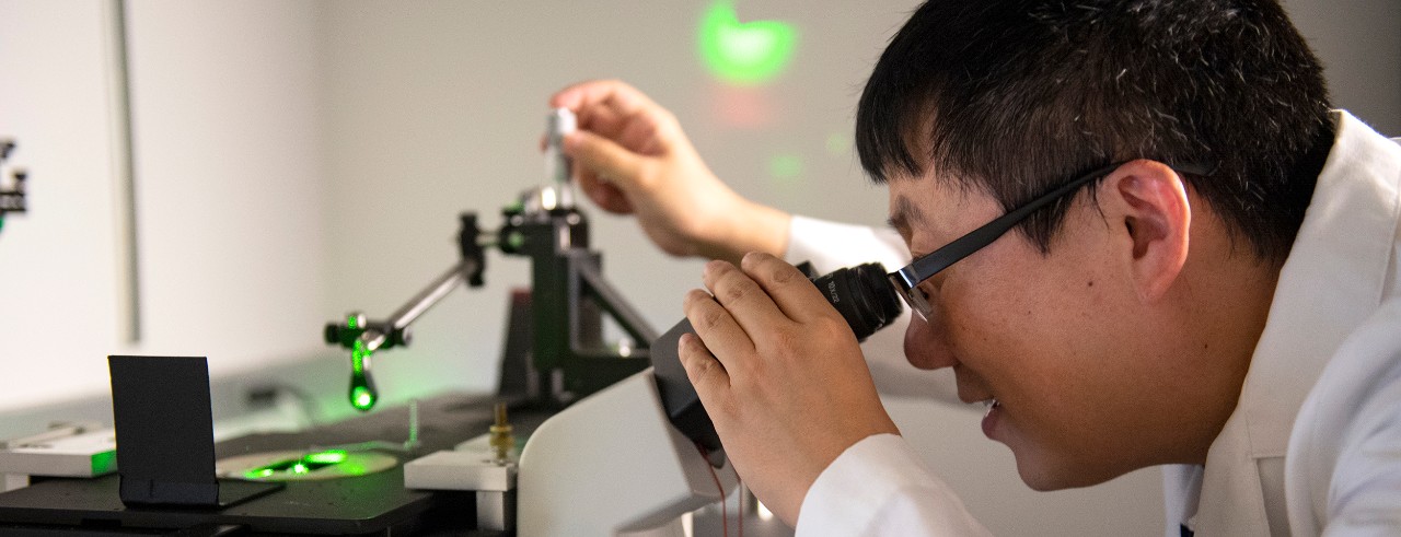 Jiajie Diao analyzes a sample with a microscope in his lab