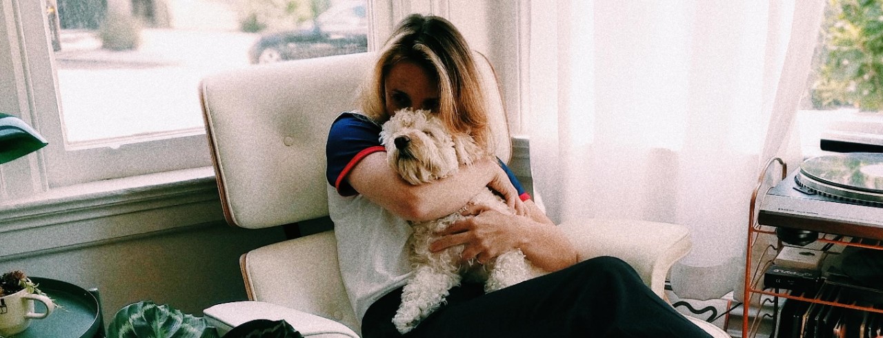 A woman hugs a dog.