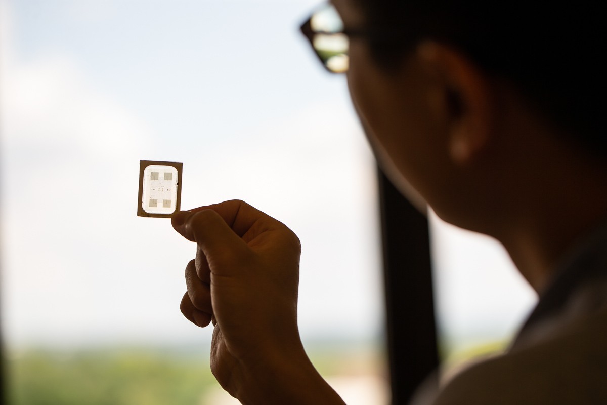 Yeongin Kim holds up his sensor to the light of a window.