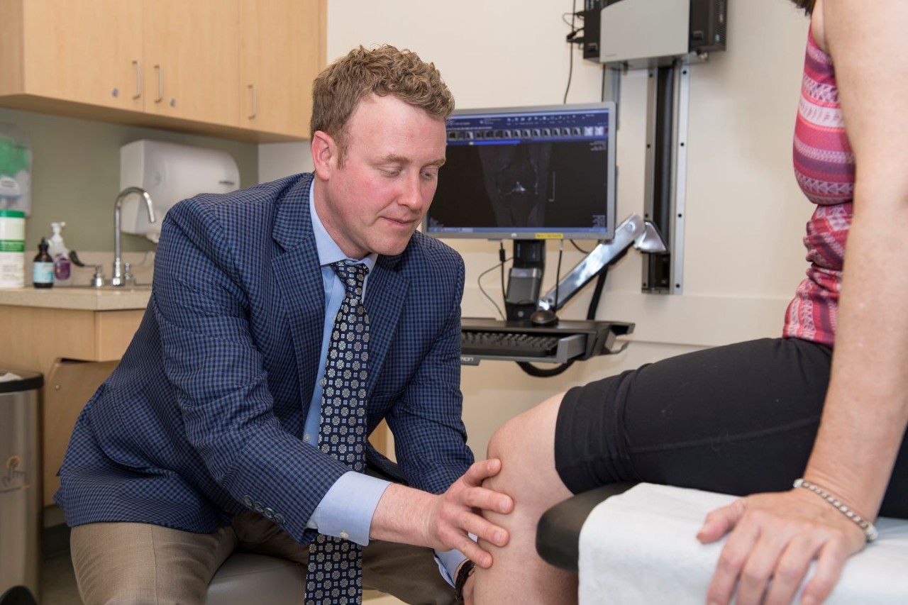 a doctor examines the knee of a patient