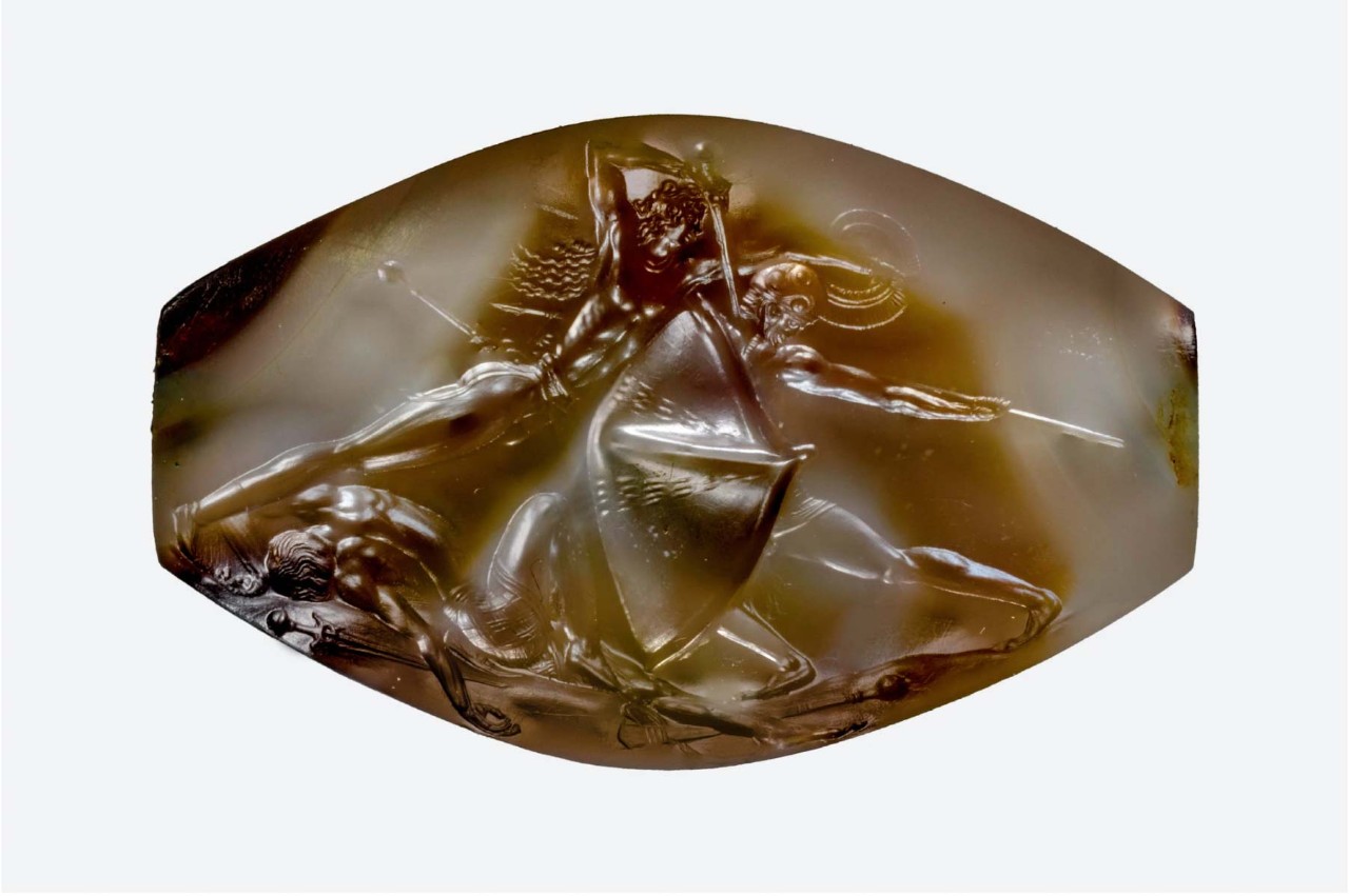 A sealstone discovered in the tomb of the Griffin Warrior depicts two soldiers, one armed with a sword; the other a spear and shield, clashing over the body of a fallen soldier. 