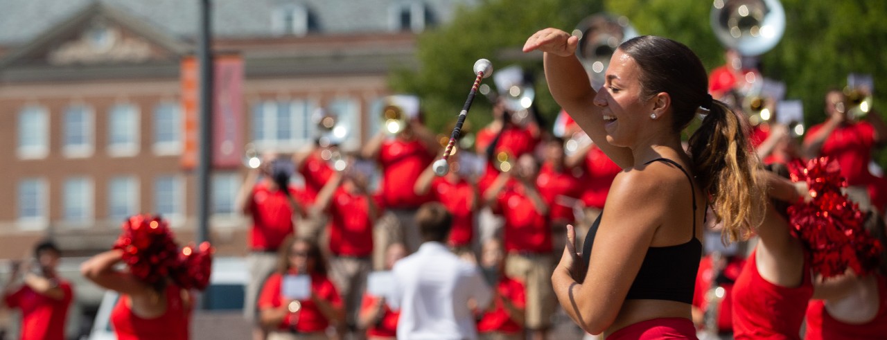 UC marching band plays while cheerleader shows spirit at UC Family Weekend pep rally