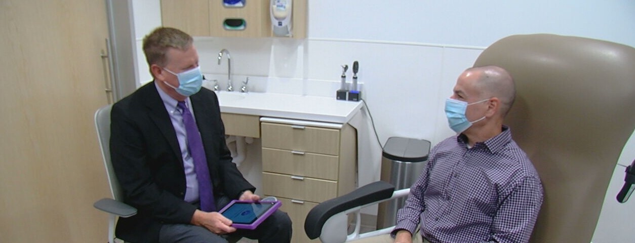 Dr. David M. Ficker talks with patient Scott Badzik in an exam room