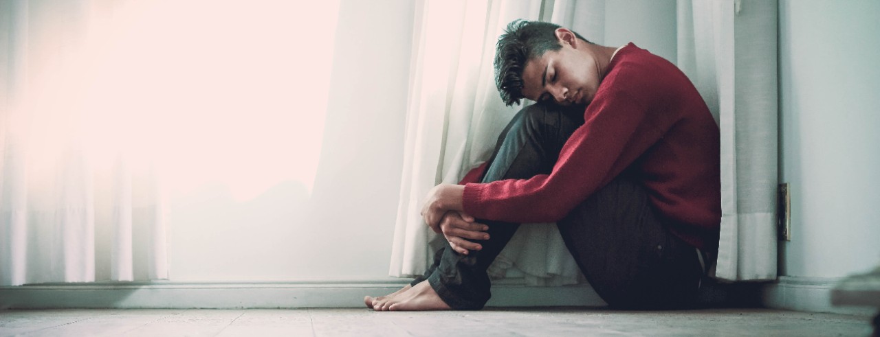 A teen sits on the floor