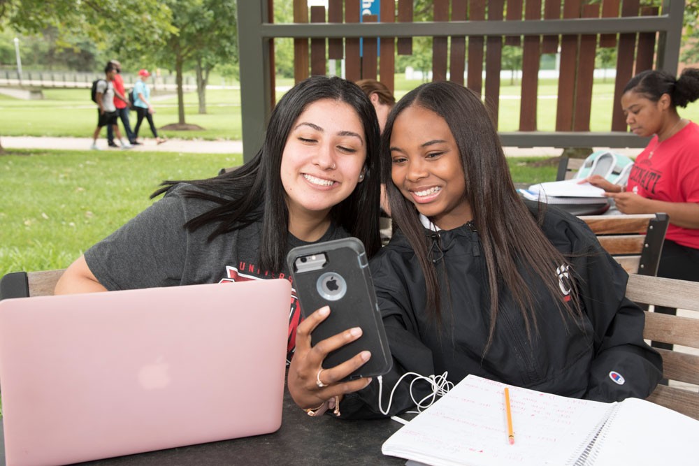 Students posing for selfie on the UC Blue Ash campus patio